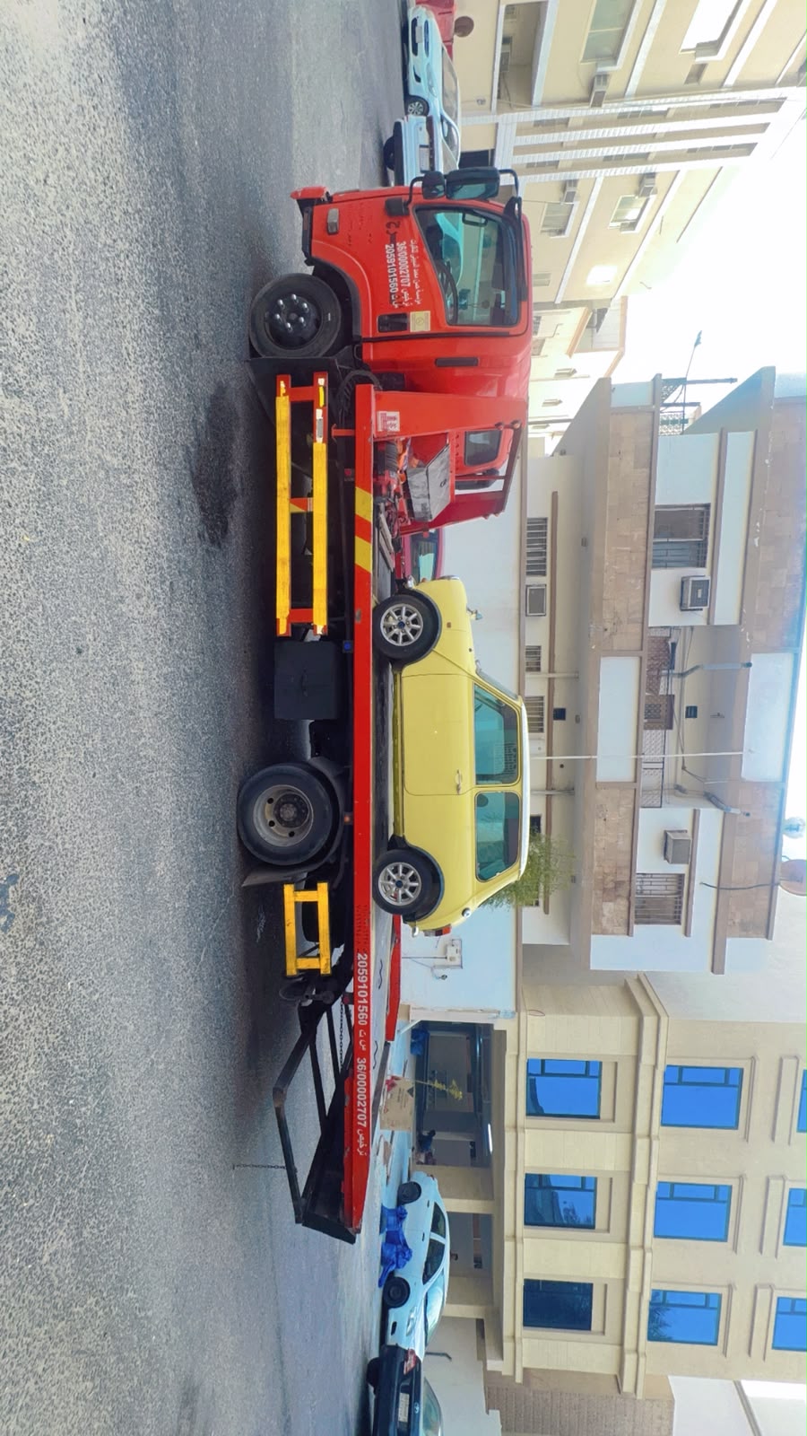 Towing Service Dammam - flatbed truck carrying a car through the city